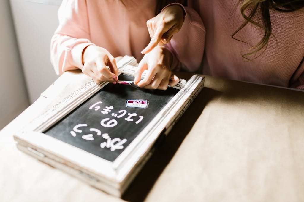 A mother and child engage in crafting activities with a decorative blackboard in a cozy setting.